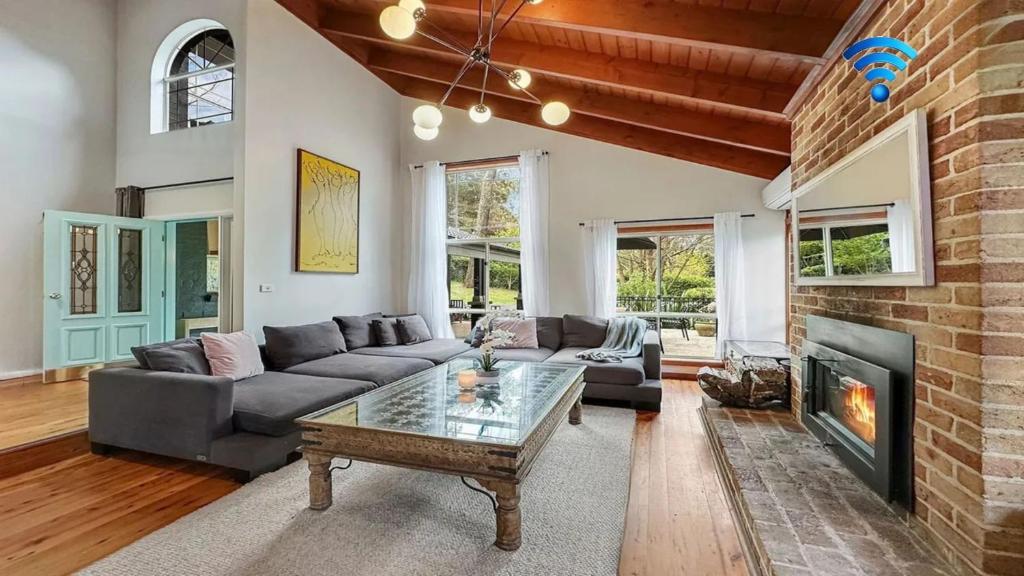 a living room with a couch and a fireplace at Mount Gibraltar Retreat in Mittagong