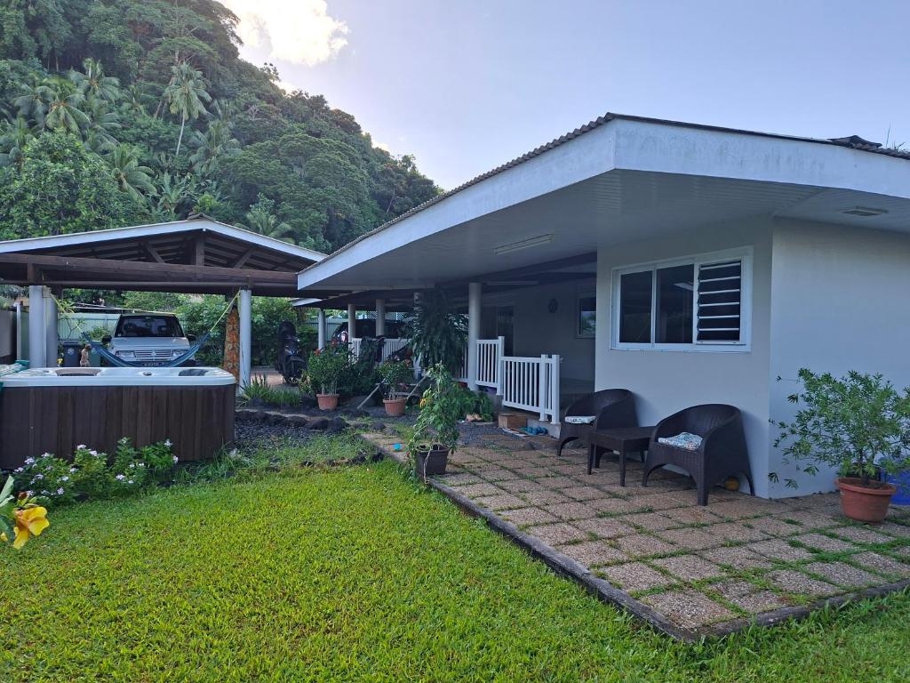 a small house with a patio and a car at Maison Tahiti in Paea