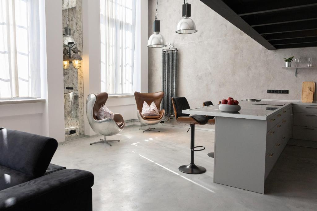 a kitchen with chairs and a table in a room at Chaya Niwas Loft in Żyrardów