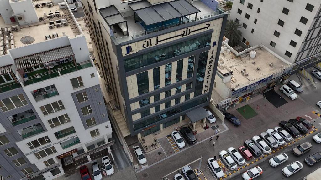 an overhead view of a tall building in a city at Jarzez Inn Hotel Azaiba فندق جرزيز إن العذيبة in Muscat