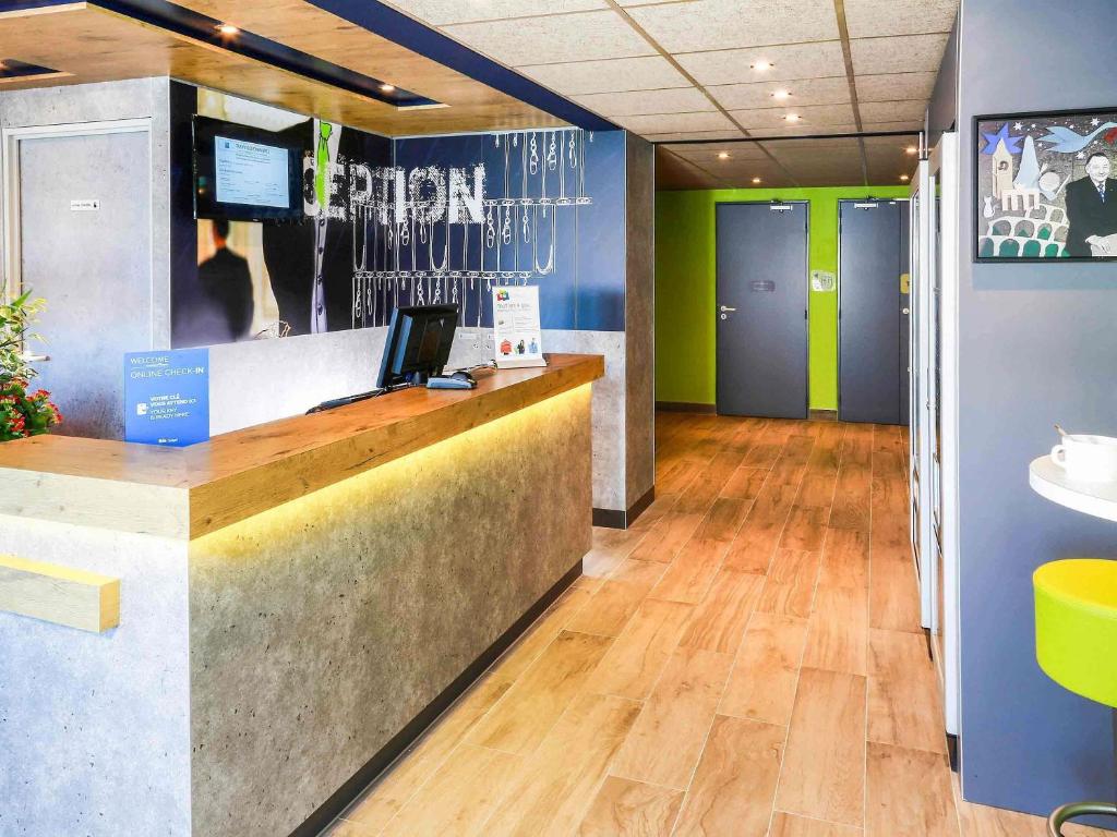 a lobby with a reception desk in a building at Ibis Budget Marseille Vitrolles in Vitrolles