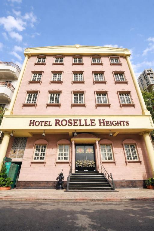 a large pink hotel with a hotel rescue hearts sign on it at Hotel Roselle Heights in Jaipur
