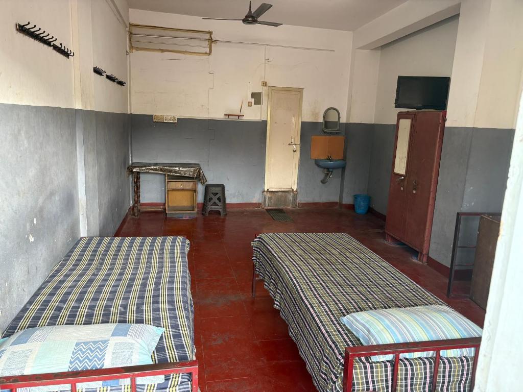 a room with two beds in a room with at Star Hostel in Kannur