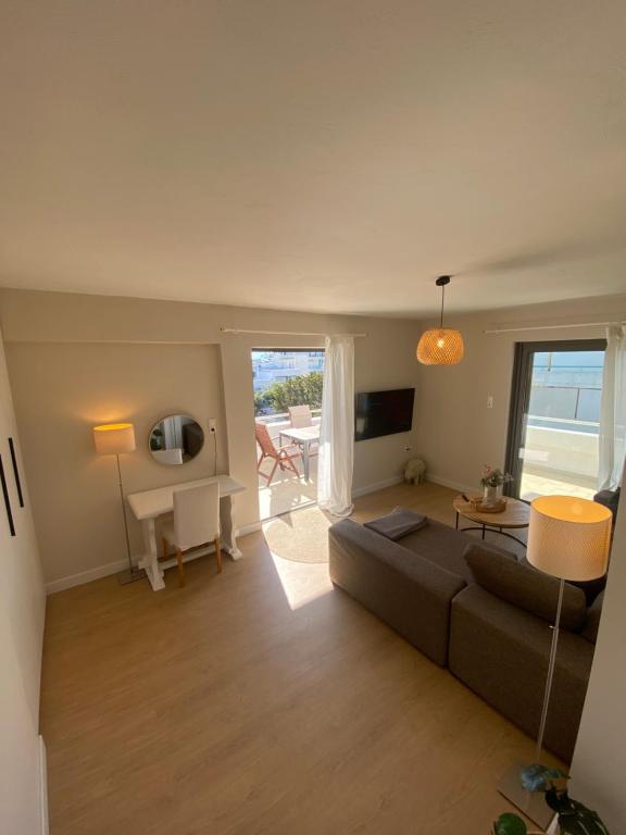 a living room with a couch and a table at The Costa Suite byArtistunknown in Vari