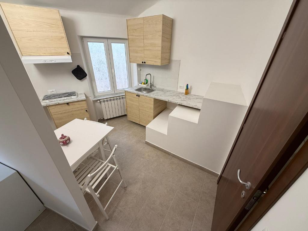 eine kleine weiße Küche mit Theke und Tisch in der Unterkunft Cielo in Mele