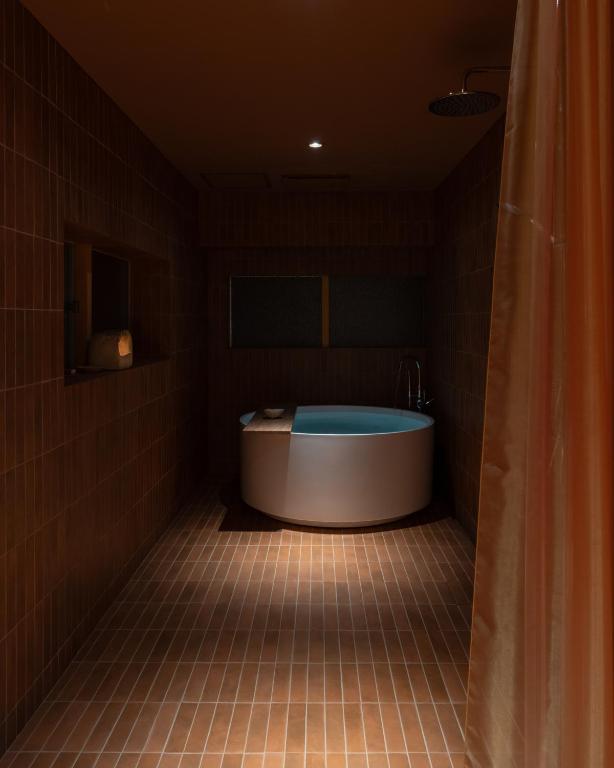 a bathroom with a tub in a dark room at 蜜圡 Mitzdo in Tamano