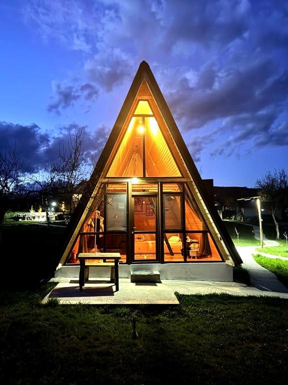 a small house with a bench in front of it at Horezu Cozy Cabin in Izvoru Rece