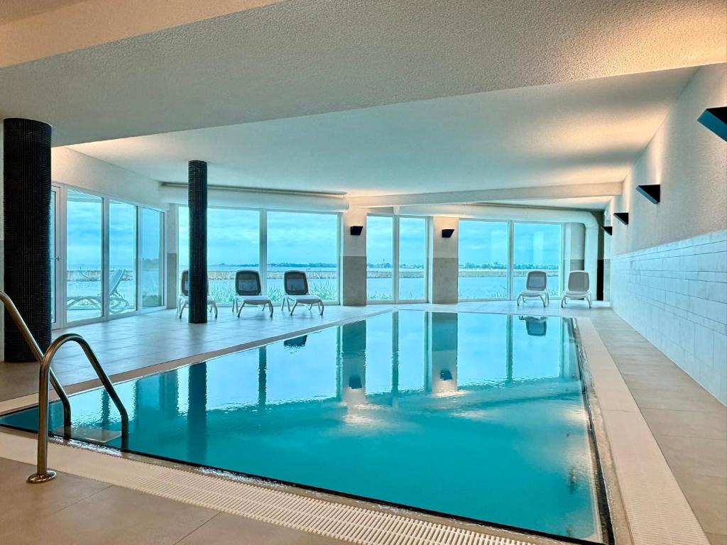 a large swimming pool with a view of the ocean at Ostseeblick-Bollwark Whg 9 in Olpenitz