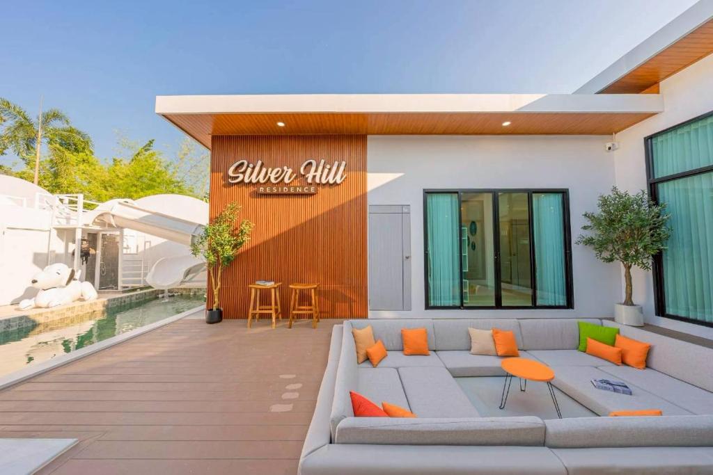 a patio with a couch and orange pillows at Silver Hill Pool Villa Pattaya in Na Jomtien