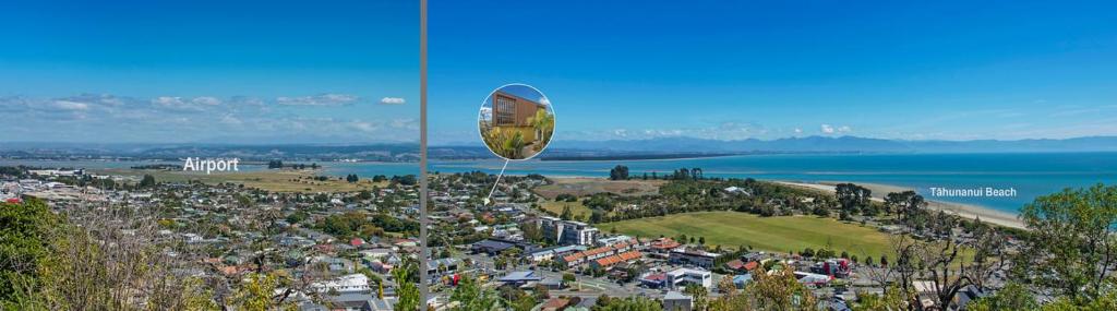 a kite flying in the air over a city at Tahuna Beach Oasis in Nelson
