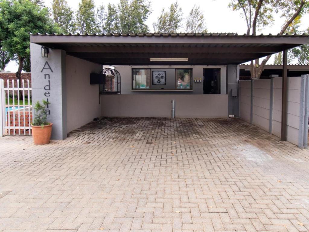 a building with a garage with a brick driveway at Andela Guesthouse in Bloemfontein