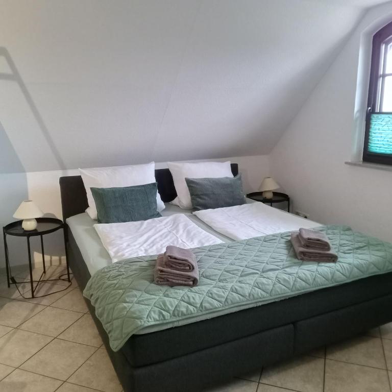 a bed with two towels on it in a room at Fischstübchen Neeberg Apt 1 – Wald und Wiese in Krummin