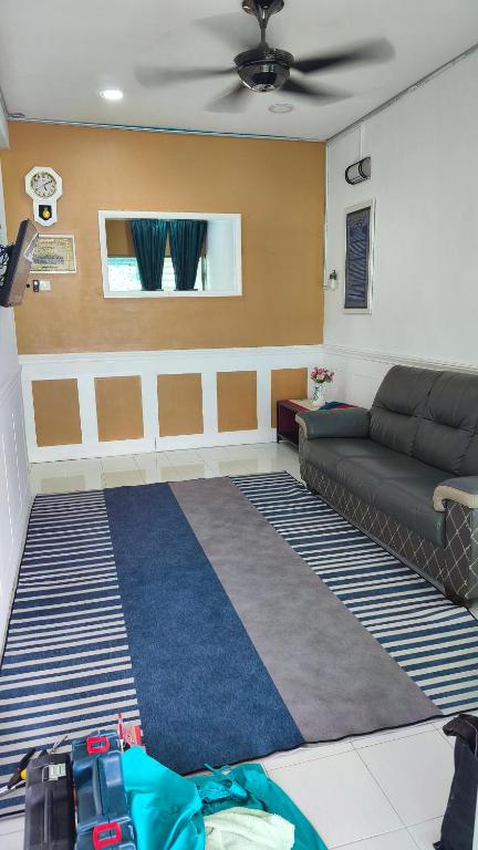 a living room with a couch and a rug at MatiinJannah Homestay Arau in Arau