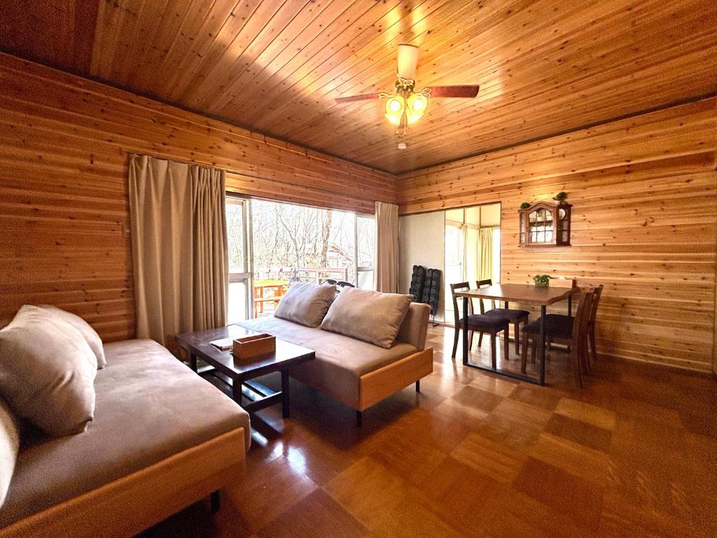 a living room with a couch and a table at SSK Mountain Base in Tsumagoi
