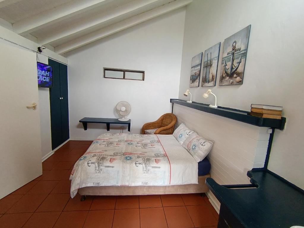a bedroom with a bed and a table in it at Sandkasteel Self-Catering Accommodation in Vosburg