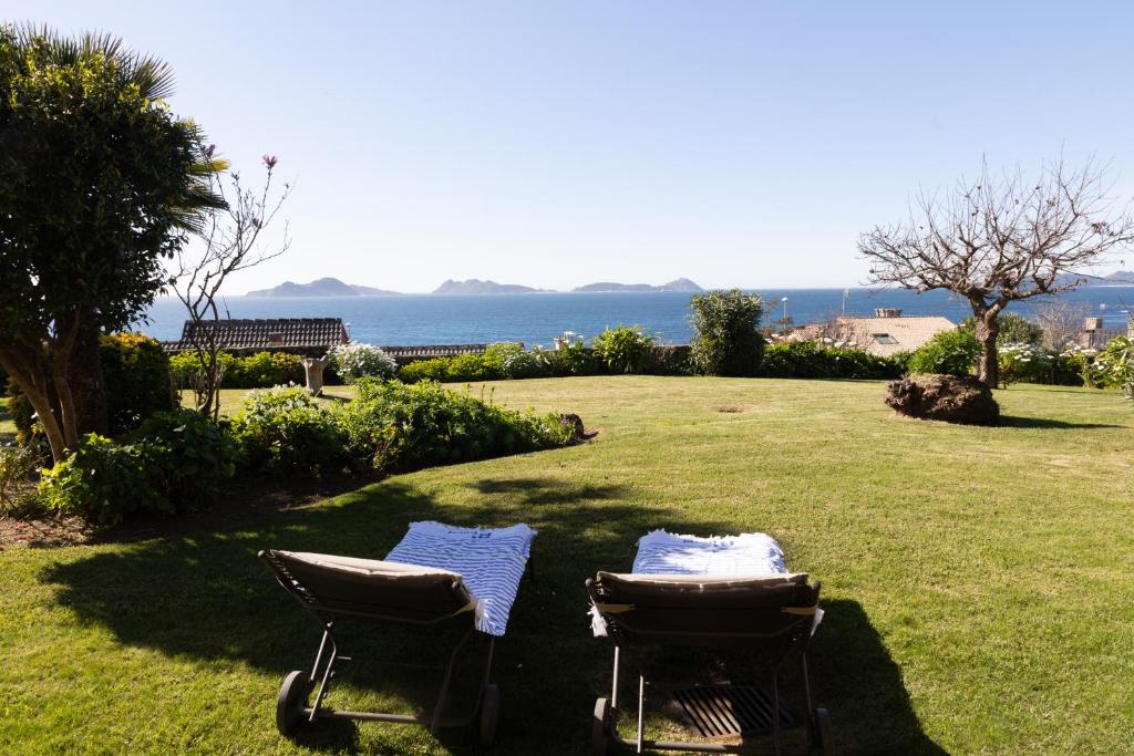 two chairs sitting in the grass near the ocean at Apartamento Saiáns in Oya