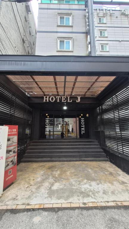 a building with a hotel sign on the front of it at Osan J Hotel in Osan