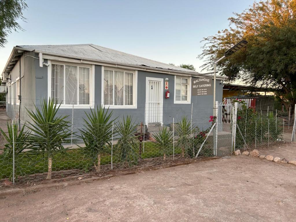 a grey house with a fence in front of it at Maltahöhe Self Catering in Maltahöhe