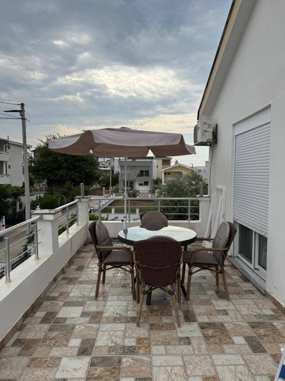 a patio with a table and chairs and an umbrella at Villa Mane in Donji Štoj