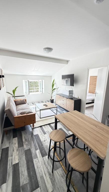 a living room with a table and two stools at Robert in Verdun-sur-Meuse