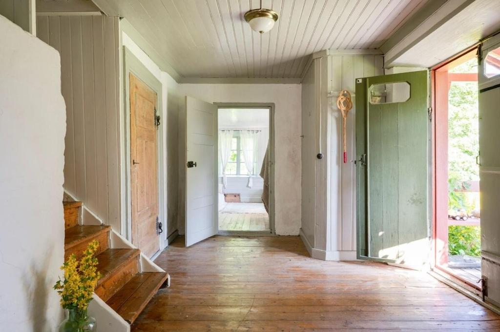 a hallway of a home with wood floors and a door at Charming Farmhouse in Gammelbo