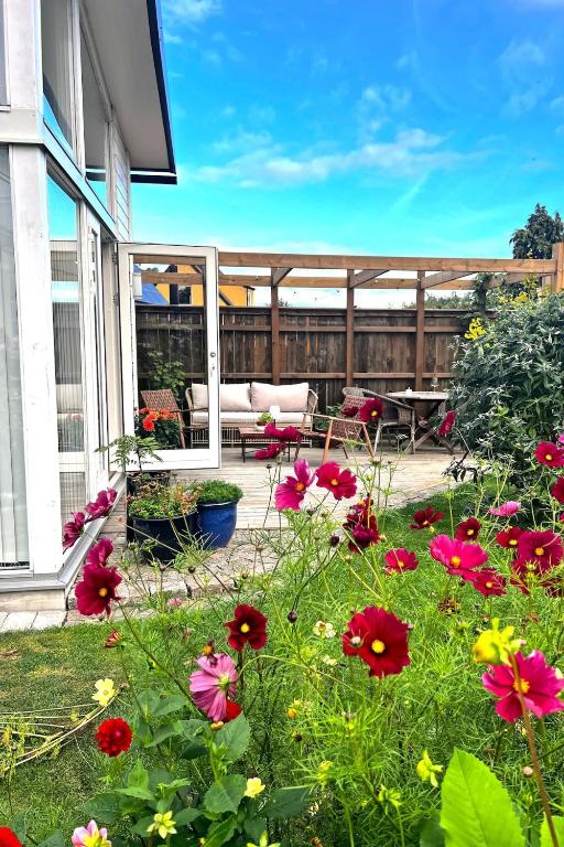 a garden with flowers in front of a house at Harbor Breeze & Garden Peace in Åhus