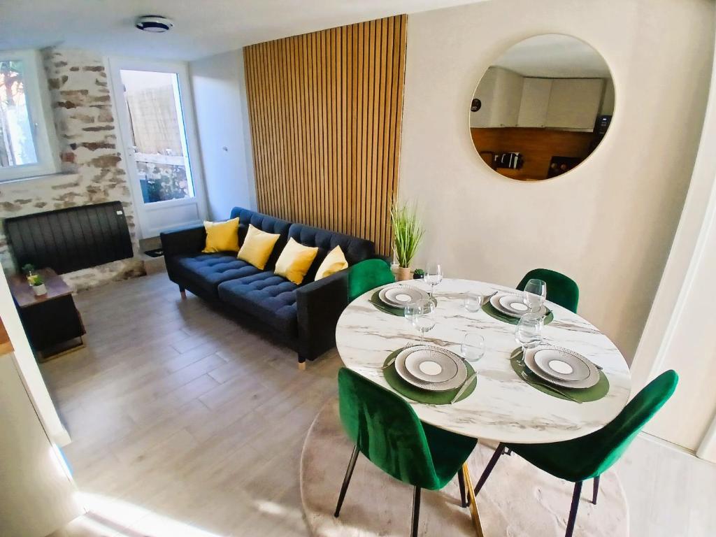 a living room with a table and a couch at L Oasis Cosy Sauna Privé et Jardin in Bouguenais