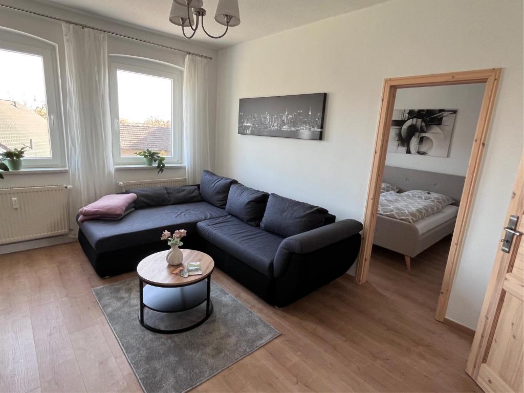 a living room with a blue couch and a table at Ferienwohnung 1A in Fockendorf