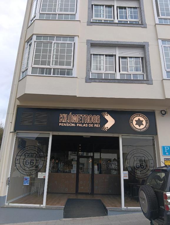 a store front of a building with a sign on it at Pensión KM66 Palas de Rei in Palas de Rei