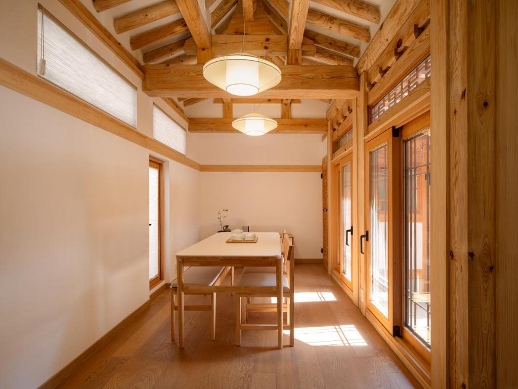 a dining room with a table and some windows at Luxury Hanok On169 in Seoul