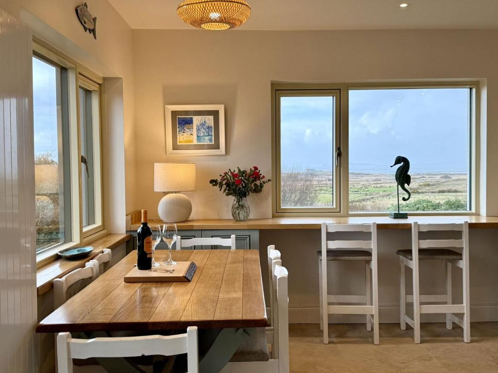a dining room with a table and a bird on the windows at Cottage 498 - Cleggan in Cleggan