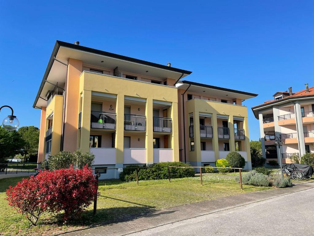 an apartment building with a fence in front of it at Marina Fiorita in Grado