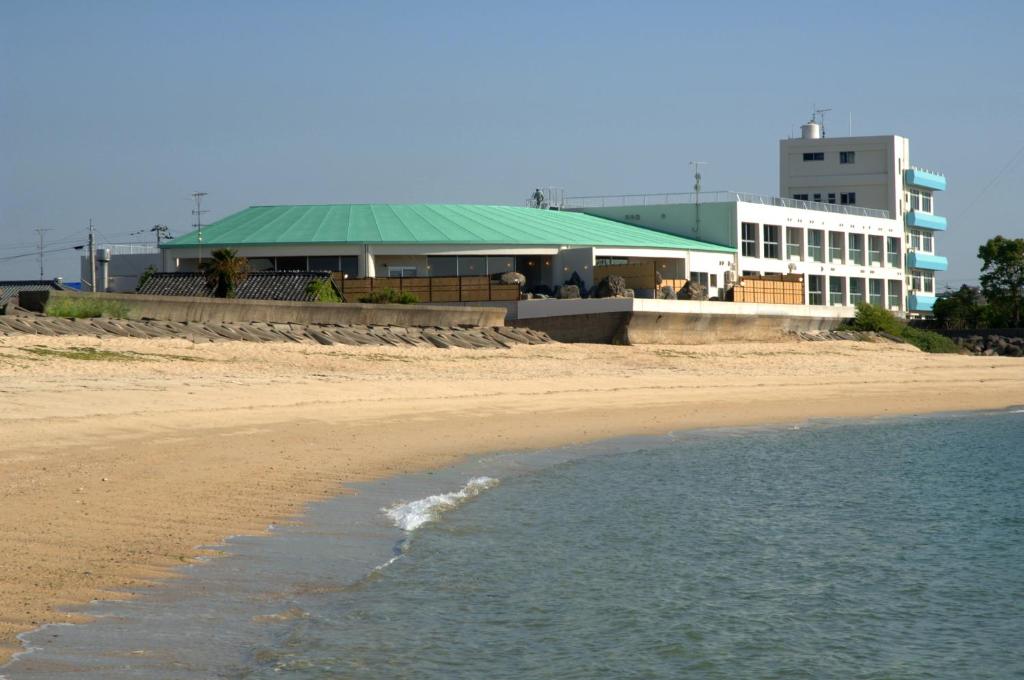 a building on the beach next to the ocean at シーパの湯 Seapa Makoto in Matsuyama