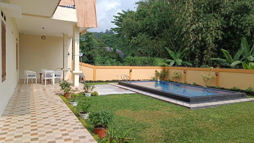 a swimming pool in the yard of a house at Villa 4 Kamar Tidur Dengan Kolam Renang Pribadi in Puncak
