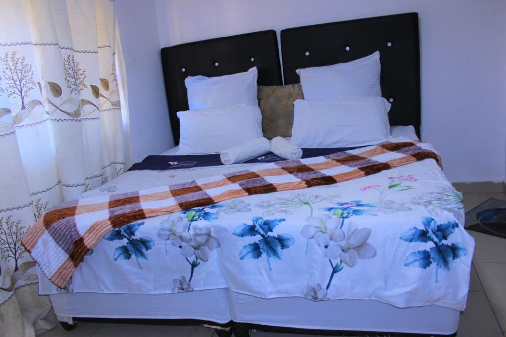 a bedroom with a bed with blue flowers on it at Inspan Home & Lodge in Bellville South