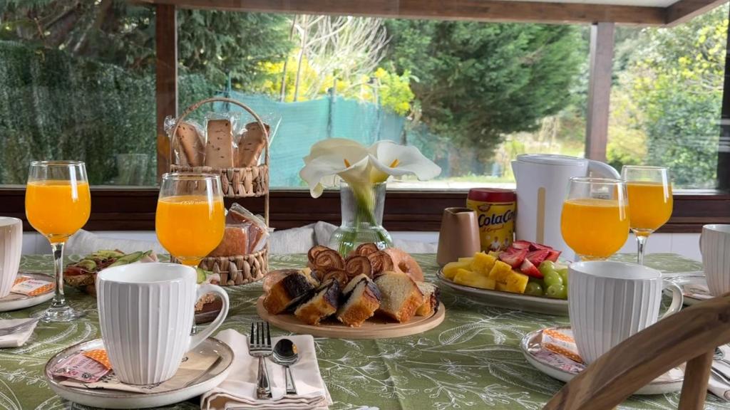 a table topped with plates of food and glasses of orange juice at Casa PREGONDA in Isla