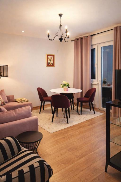a living room with a table and chairs at Koviljača apartman Demetrios in Banja Koviljača