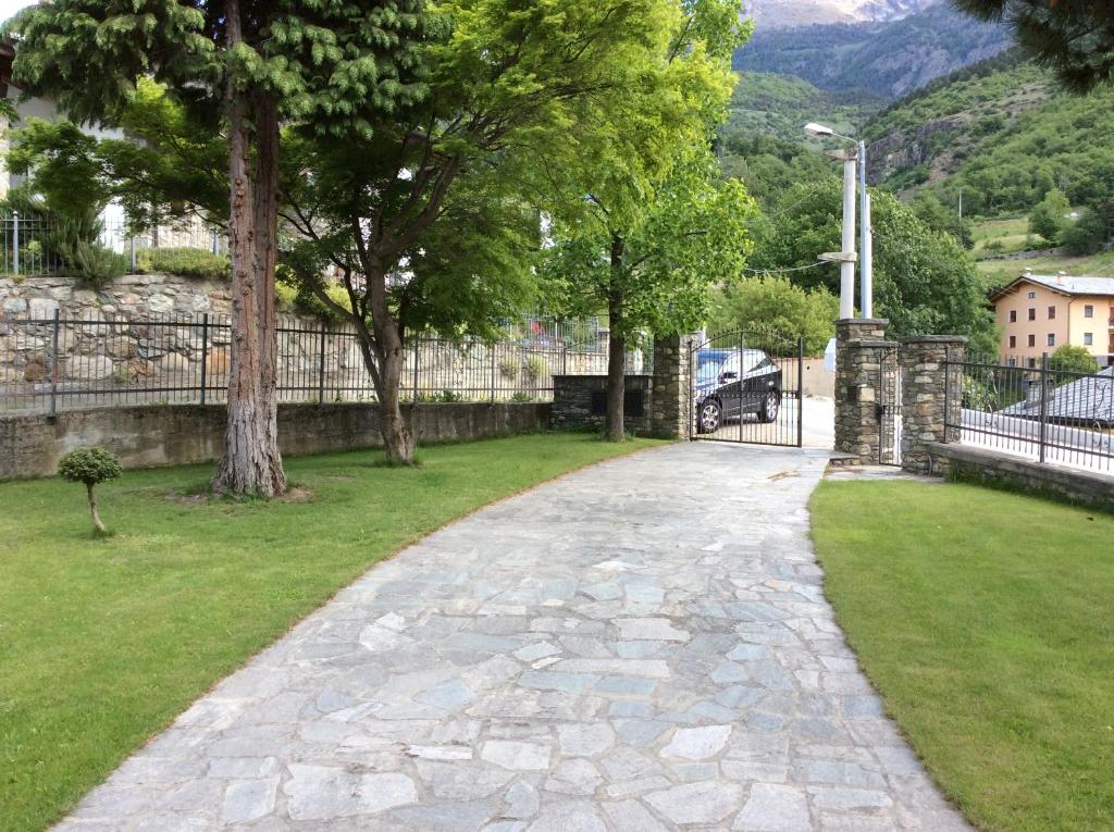 アオスタにあるGrand Arvouの木と柵の公園内石畳