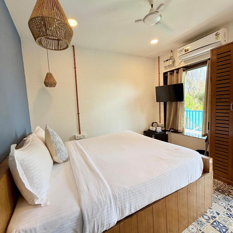 a bedroom with a white bed and a window at EKAM in Agonda