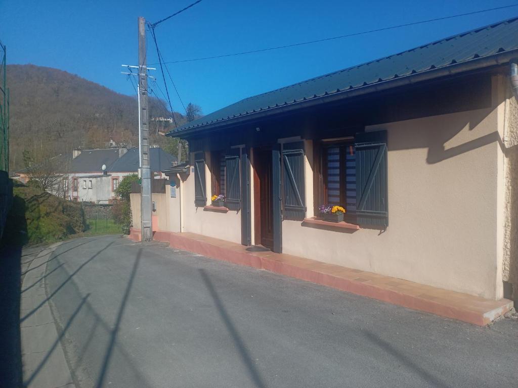 a building with windows and a street next to a road at GÎTE Le Moulineau in Deville