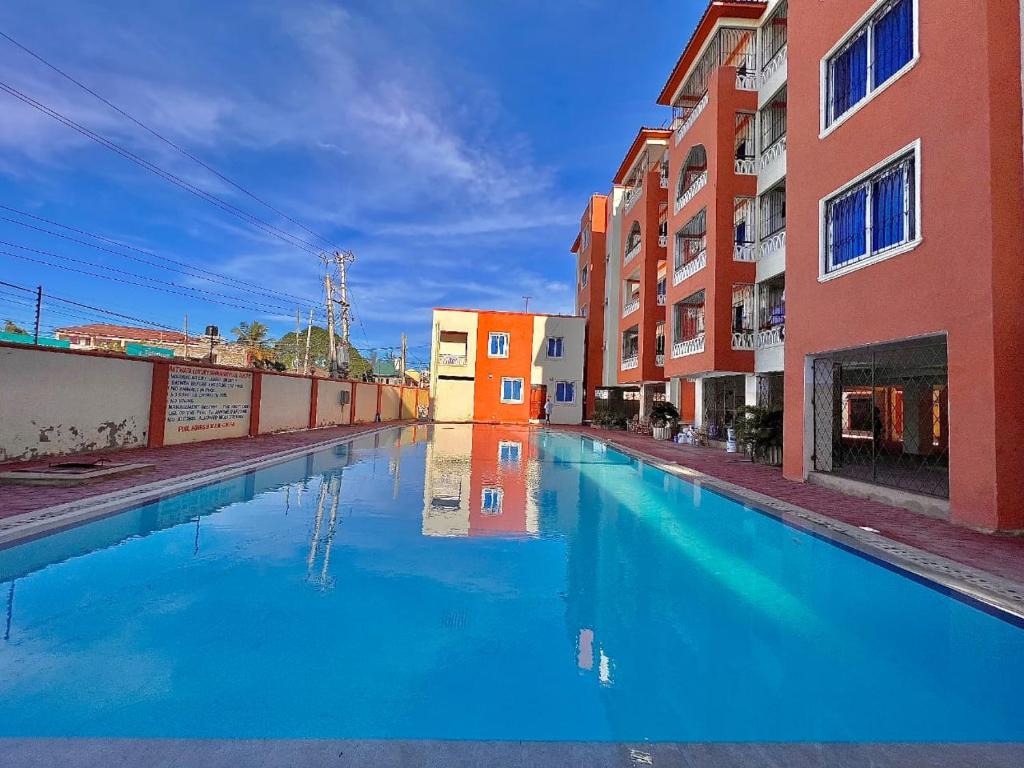 a pool of blue water in an alley between buildings at Bamburi Mombasa Three bedrooms at Cutraz homes apartments 010 in Mtwapa