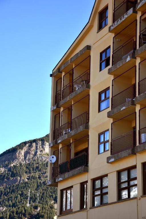 a building with a mountain in the background at Apartamentos SNÖ Cerler in Cerler