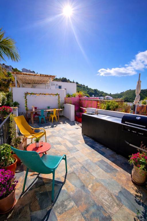 a patio with chairs and a table on a roof at Olé Toledo in Cómpeta