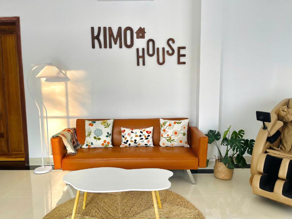 a living room with a brown couch with pillows at KIMO HOUSE Khem Beach in Phú Quốc