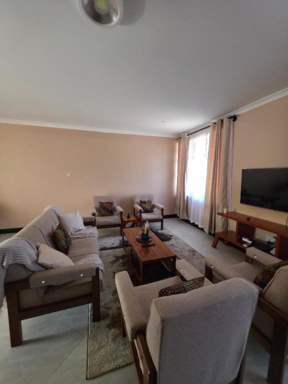 a living room with couches and a flat screen tv at Kiliheights Getaway in Sanya Chini Station