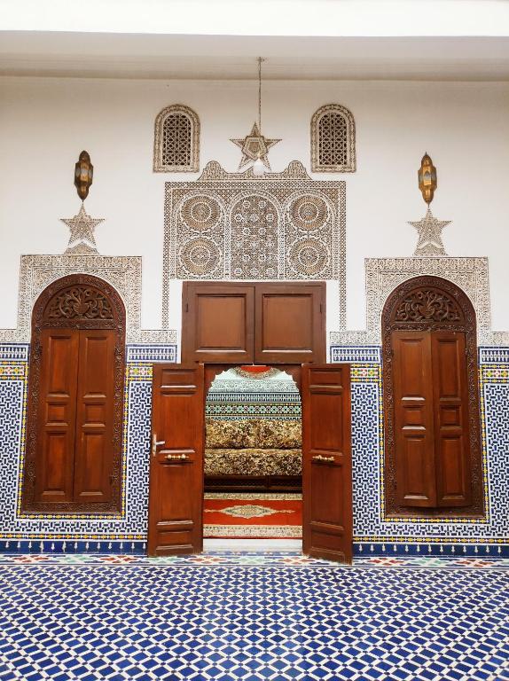 a bedroom with two doors and a bed in a room at Riad Benkirane Fes Medina in Fez