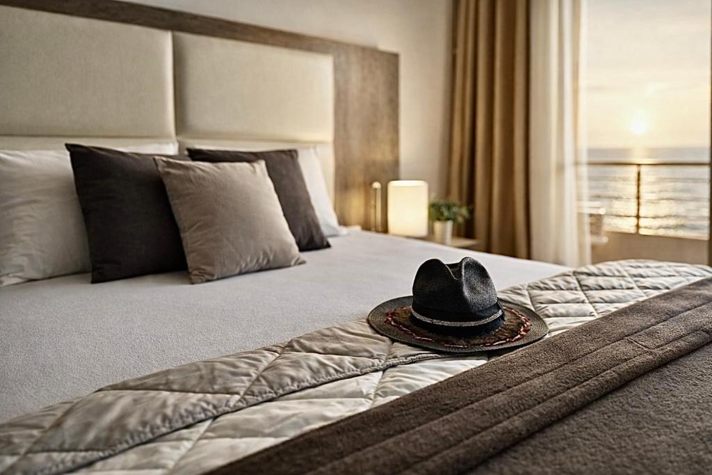 a hat sitting on top of a bed at Apart-Hotel Saraj in Dobra Voda