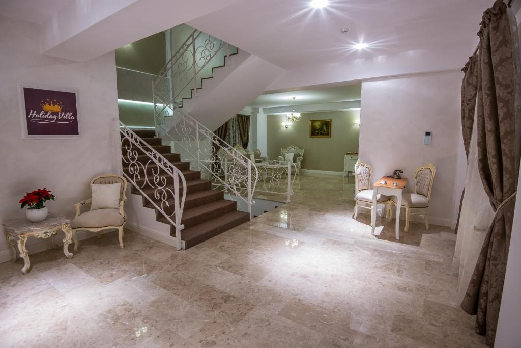 a living room with a staircase and a table and chairs at French Boutique in Braşov