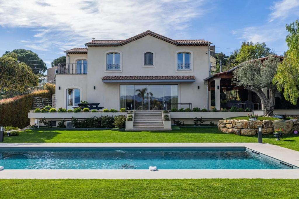a house with a swimming pool in front of a yard at REF 2193 - Super Cannes Villa for rent in Vallauris