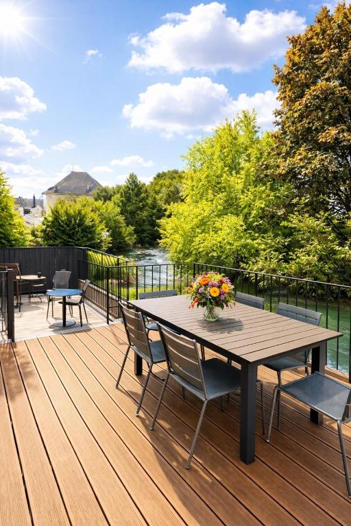 a wooden deck with a wooden table and chairs at Le Lavoir de Loches in Loches